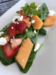 Salad with melon, berry, and goat cheese